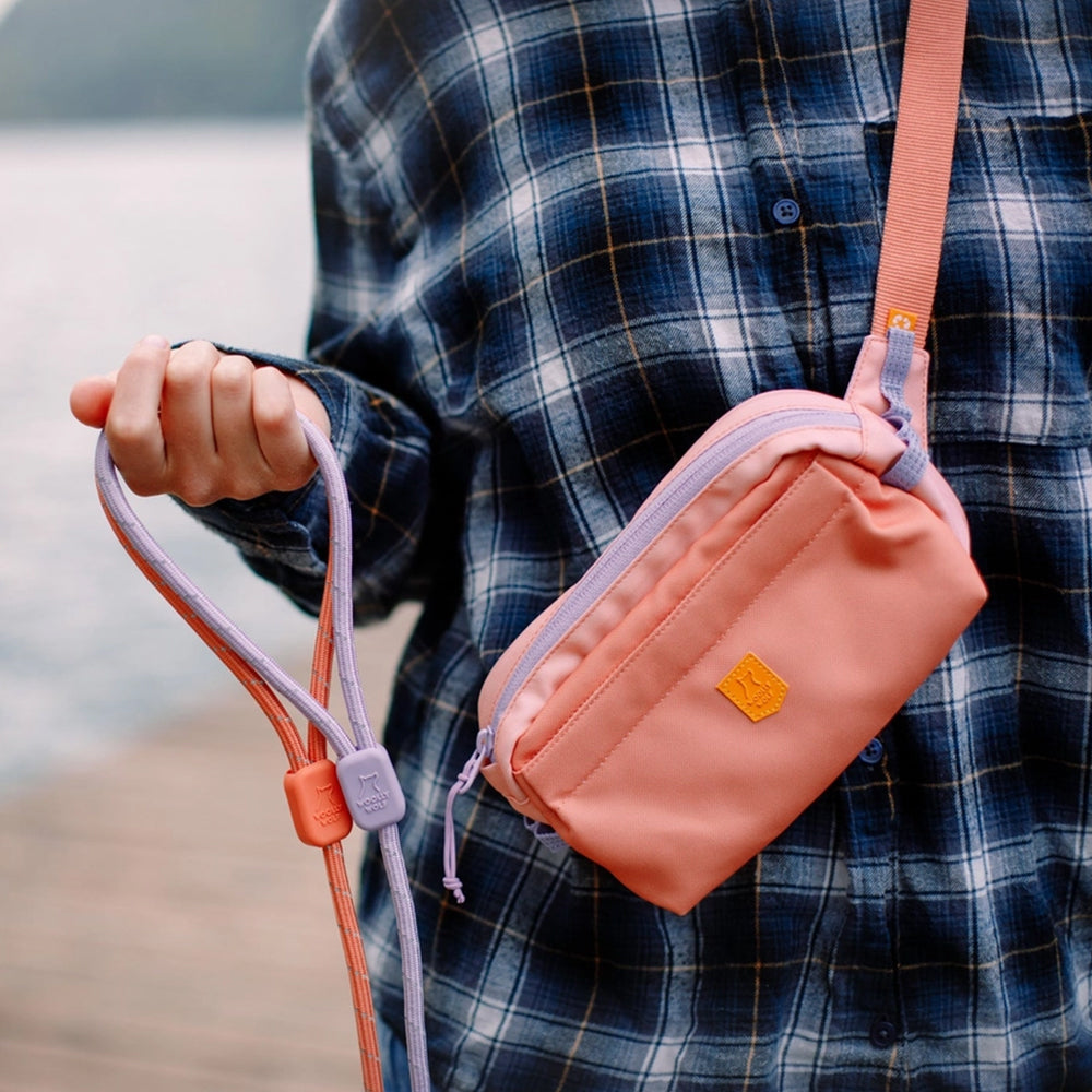 Spaziergang mit Hund – Die Alpha 360 Hip Pack in Lachsrosa sorgt für Organisation und Komfort für den Hundebesitzer.