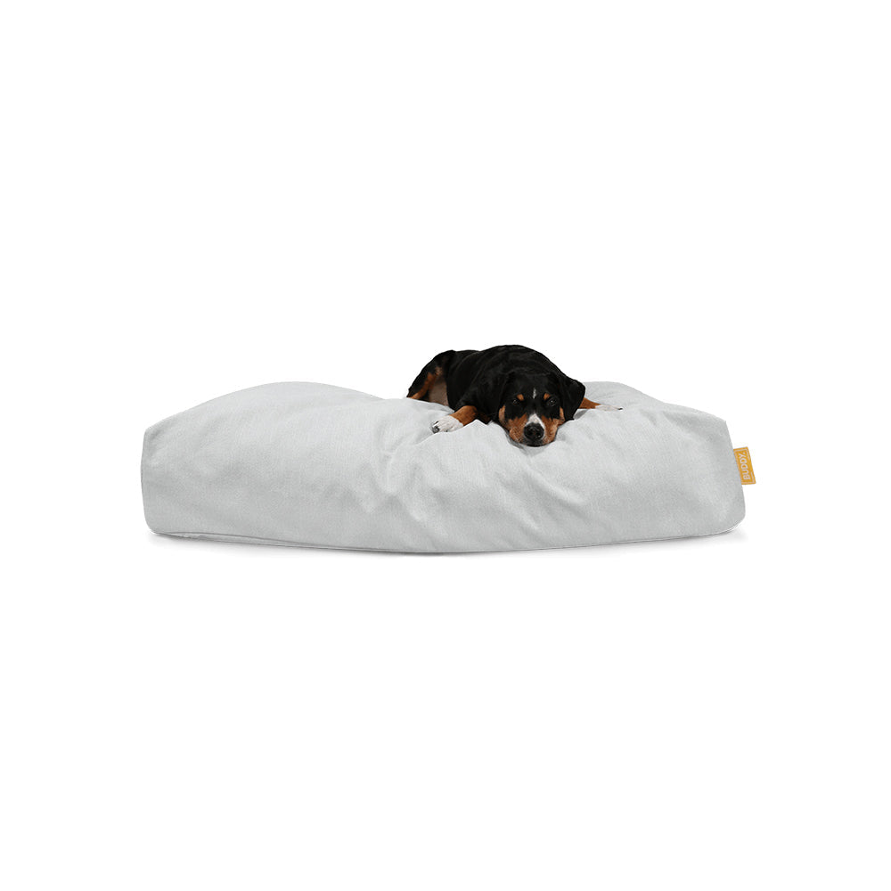 Hund liegt auf dem nachhaltigen Hundebett Jumbo in der Farbe: Stone und fühlt sich sichtlich wohl.