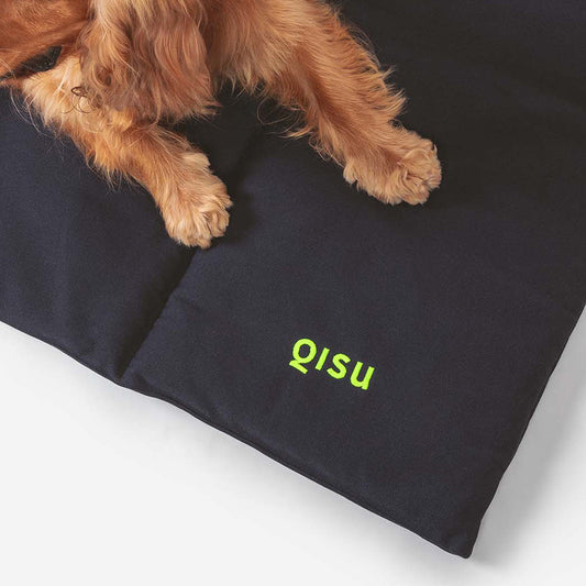 Hund liegt auf der Hundematte von Qisu. Abgerundet wird der Look durch das dezente Logo - stilvoll und nachhaltig