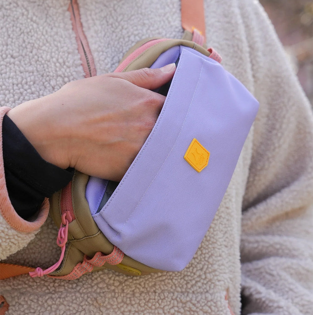 Alpha 360 Hip Pack in Lavendel Mix getragen beim Spaziergang – praktische Tasche mit Platz für Leckerlis, Handy & Hundekotbeutel.