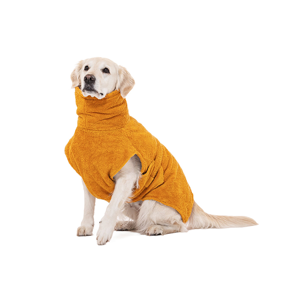 Hund sitzt im Lill’s Hundebademantel Amber vor weißem Hintergrund