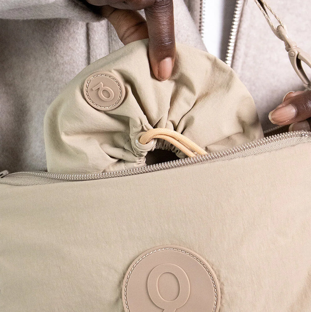 Mensch legt den faltbaren Napf in die Tasche mit nur zwei Finger - unkompliziert und effektiv.